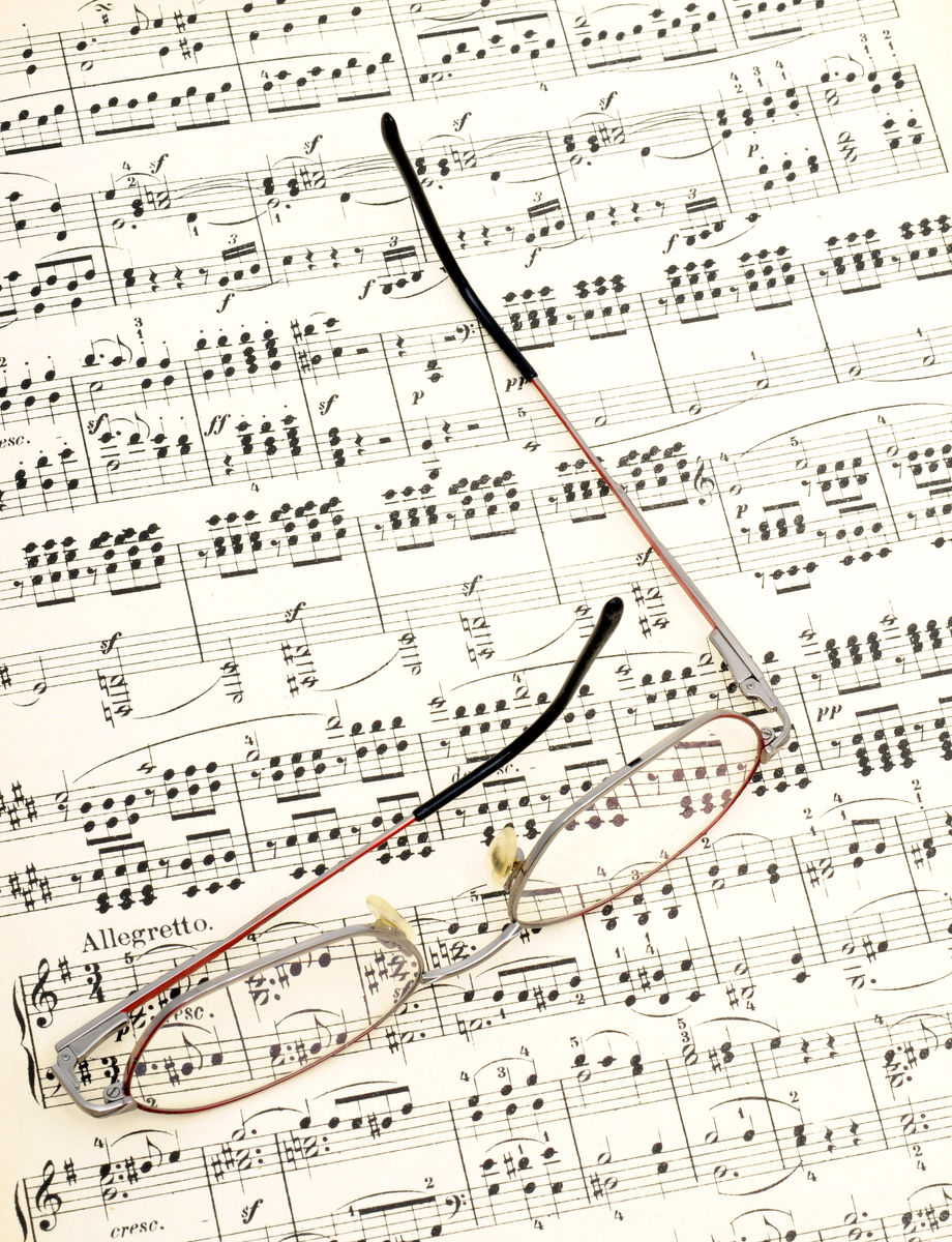 Printed sheet music with a baton and eyeglasses